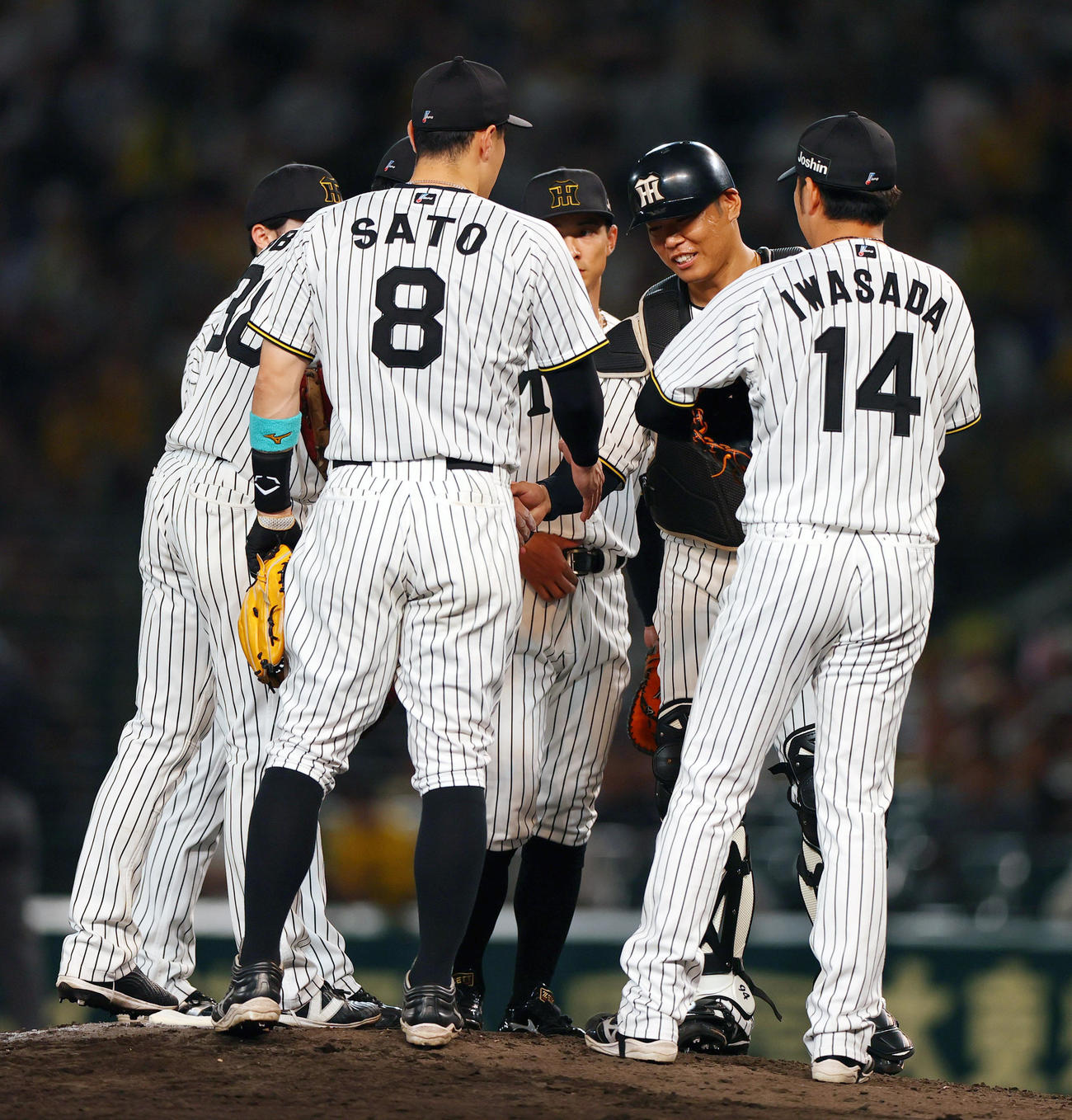 阪神対ヤクルト　9回表ヤクルト無死一塁、捕手原口（右から2人目）と岩貞（右）は交代となりマインドで内野陣と握手をかわす（撮影・上山淳一）