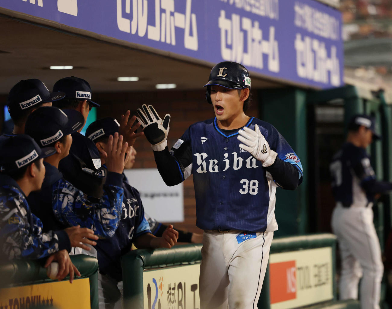 楽天対西武　2回表西武1死満塁、西川愛也の適時安打で生還しナインとタッチを交わす佐藤太（撮影・増田悦実）