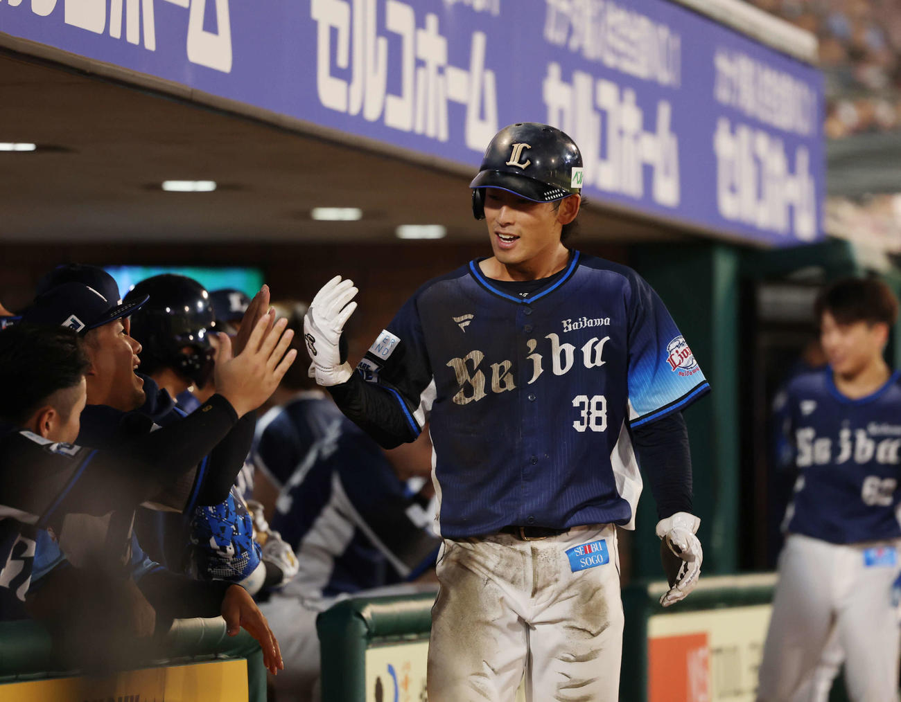 楽天対西武　8回表西武1死三塁、生還しナインとタッチを交わす佐藤太（撮影・増田悦実）