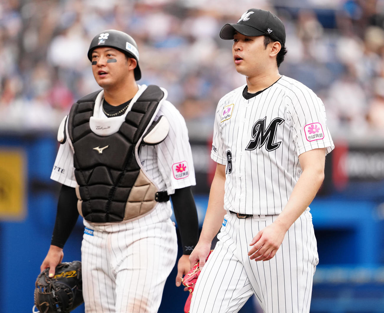 ロッテ対日本ハム　5回表を終え、佐藤（左）と話しながらベンチへ戻るロッテ種市（撮影・鈴木みどり）