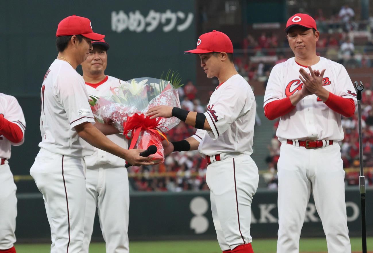 広島対ヤクルト　試合終了後、野間（左）から花束を受け取る上本。右は新井監督（撮影・加藤孝規）