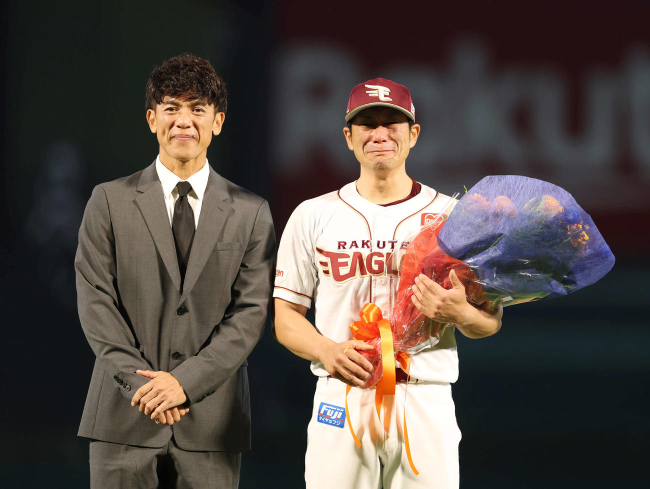 楽天対西武　引退セレモニーで松井さん（左）に花束をもらい涙を見せる楽天岡島（撮影・増田悦実）