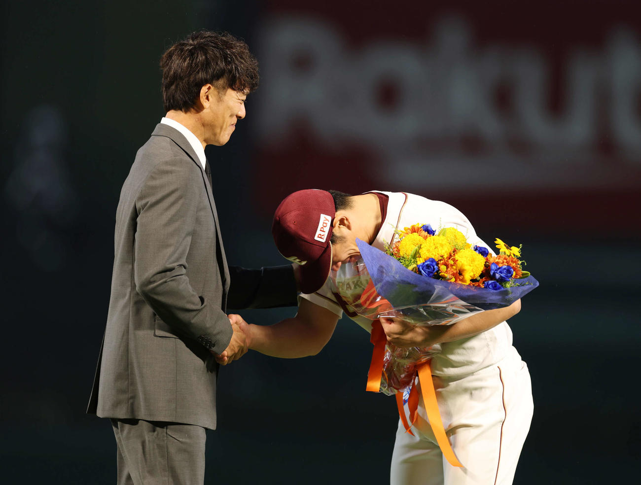 楽天対西武　引退セレモニーで松井さん（左）に花束をもらい涙を見せる楽天岡島（撮影・増田悦実）