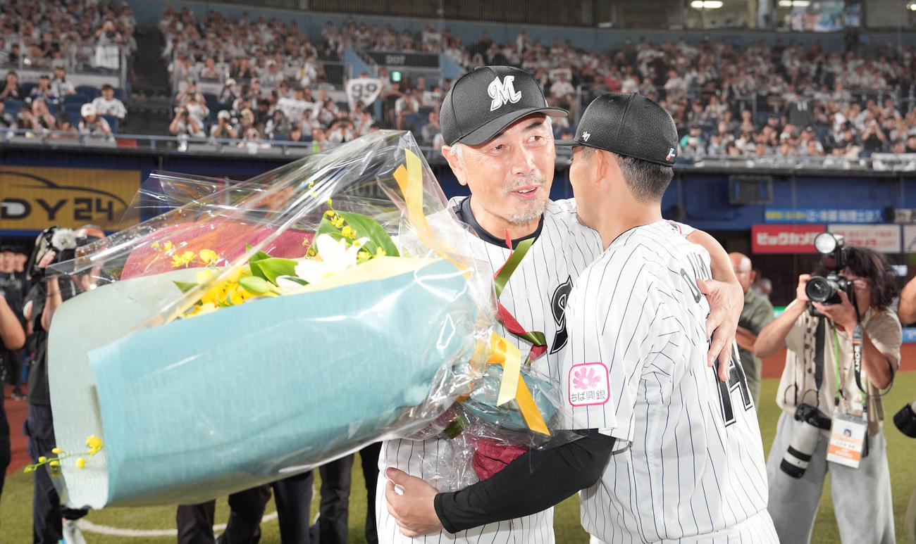ロッテ対ソフトバンク　今季限りで退任するロッテ吉井監督（左）は小島から花束を受け取る（撮影・鈴木みどり）