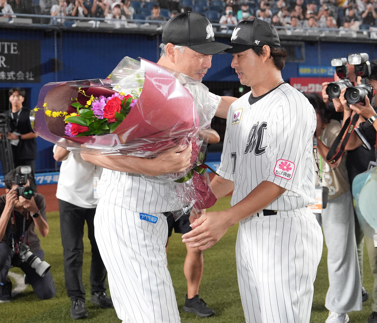 ロッテ対ソフトバンク　今季限りで退任するロッテ吉井監督（左）は藤岡から花束を受け取る（撮影・鈴木みどり）