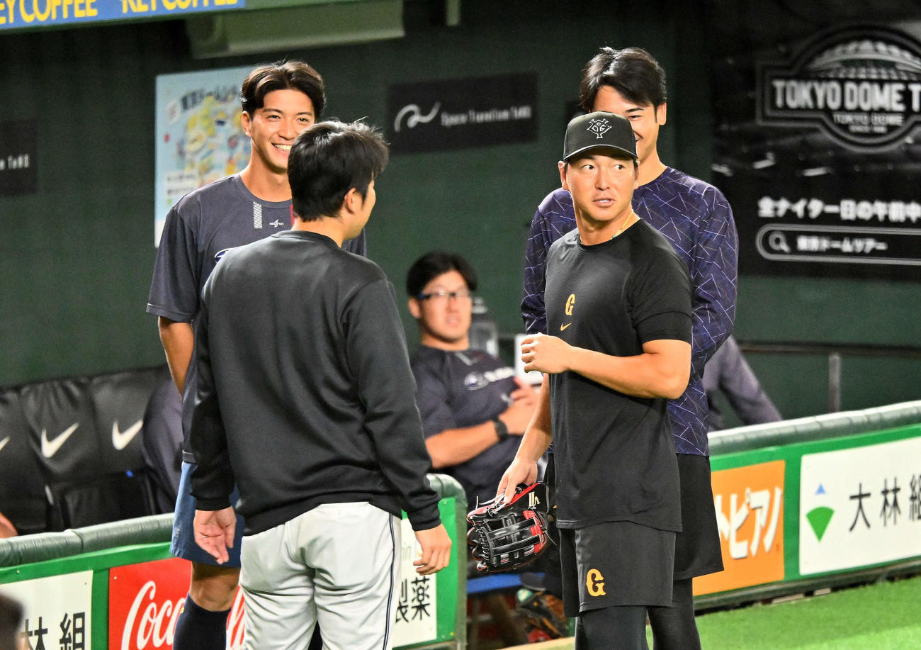 巨人対SUBARU　試合前練習で巨人長野（右手前）はSUBARUの選手と談笑する（撮影・滝沢徹郎）