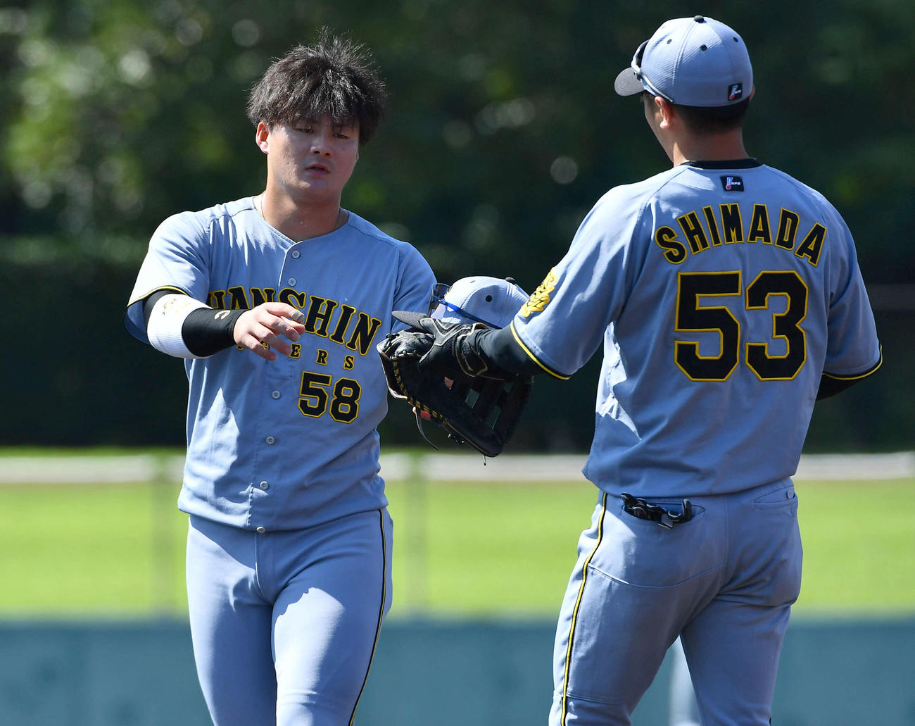 韓国ハンファ対阪神　1回表終了後、先制打を放った前川（左）は島田からグラブを受け取る（撮影・岩下翔太）