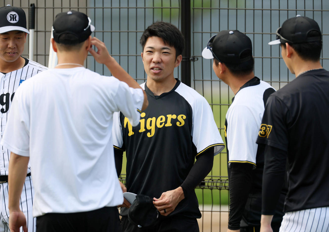 明るい表情で投手陣と話す阪神石井（撮影・加藤哉）