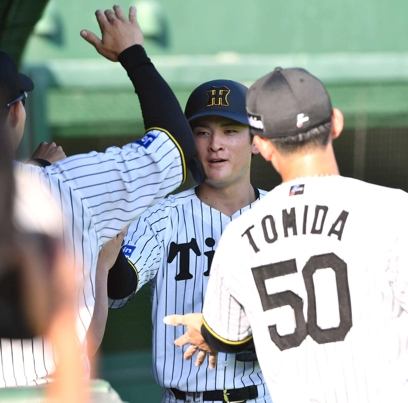 阪神対中日　8回裏阪神2死三塁、楠本の勝ち越し打で生還し、ナインとタッチを交わす高寺（撮影・岩下翔太）