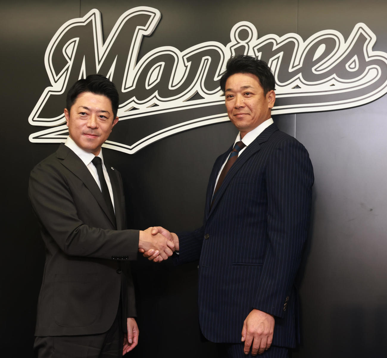 就任会見で高坂社長（左）と握手するロッテのサブロー新監督（撮影・野上伸悟）