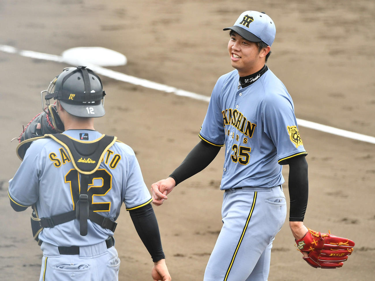 西武対阪神　2回裏を3者凡退に抑えた才木（右）は坂本と笑顔で話しながらベンチへ戻る（撮影・岩下翔太）