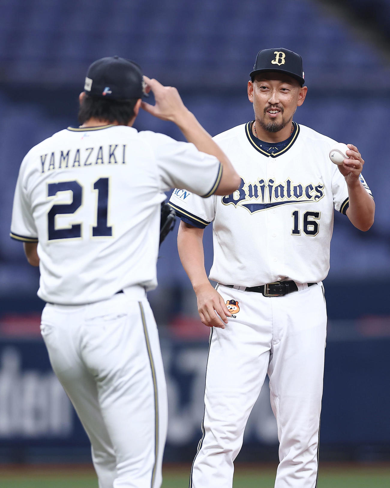 紅白戦の4回表、マウンドに上がる山崎（左）にボールを渡す平野（撮影・前田充）