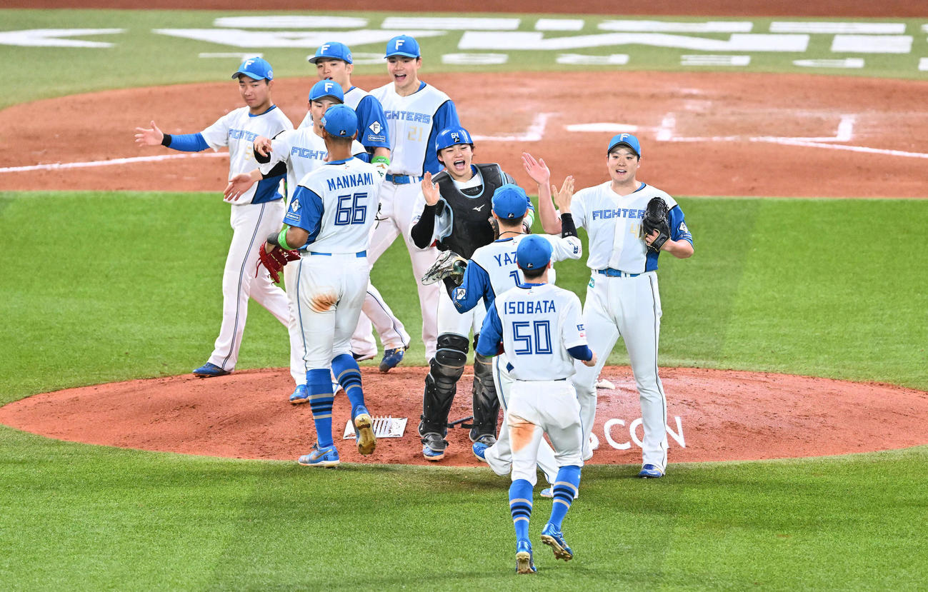 日本ハム対オリックス　勝利を飾りタッチを交わす日本ハムの選手たち（撮影・滝沢徹郎）