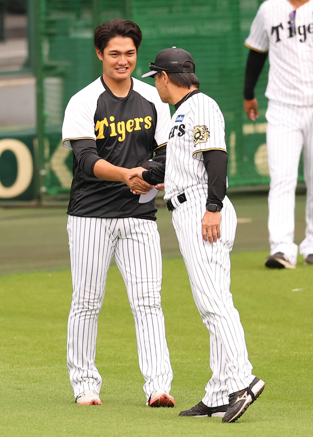 和田一軍・二軍打撃巡回コーディネーター（右）と握手を交わす西純（撮影・上田博志）