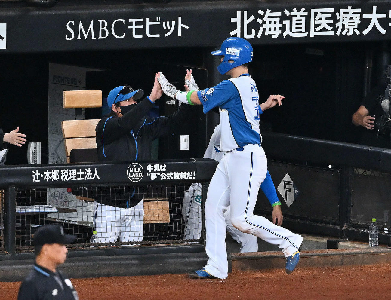 日本ハム対オリックス　2回裏日本ハム1死三塁、万波の先制適時打で生還した郡司（手前）とタッチを交わす新庄監督（撮影・滝沢徹郎）