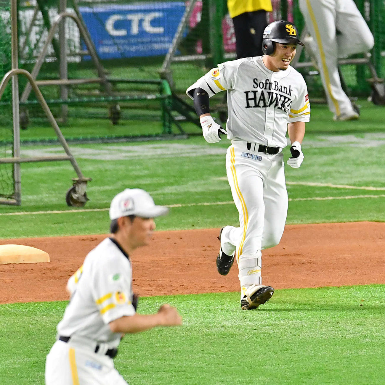 ライブBPで安打性の打球を放ち、笑顔を見せるソフトバンク栗原。左は小久保監督（撮影・岩下翔太）