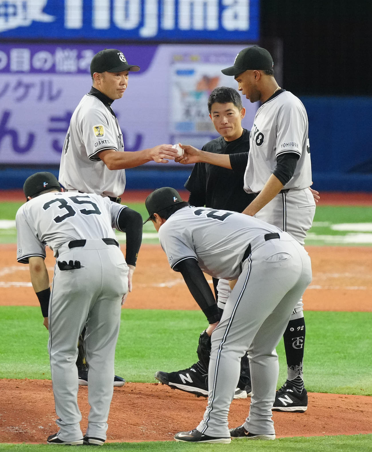 DeNA対巨人　8回裏途中、巨人7番手のマルティネス（右）にボールを渡す阿部監督（撮影・江口和貴）