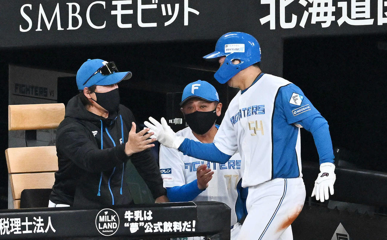 日本ハム対オリックス　2回裏日本ハム1死二塁、水谷の中前適時打をで生還した山県（右）とタッチを交わす新庄監督（撮影・滝沢徹郎）