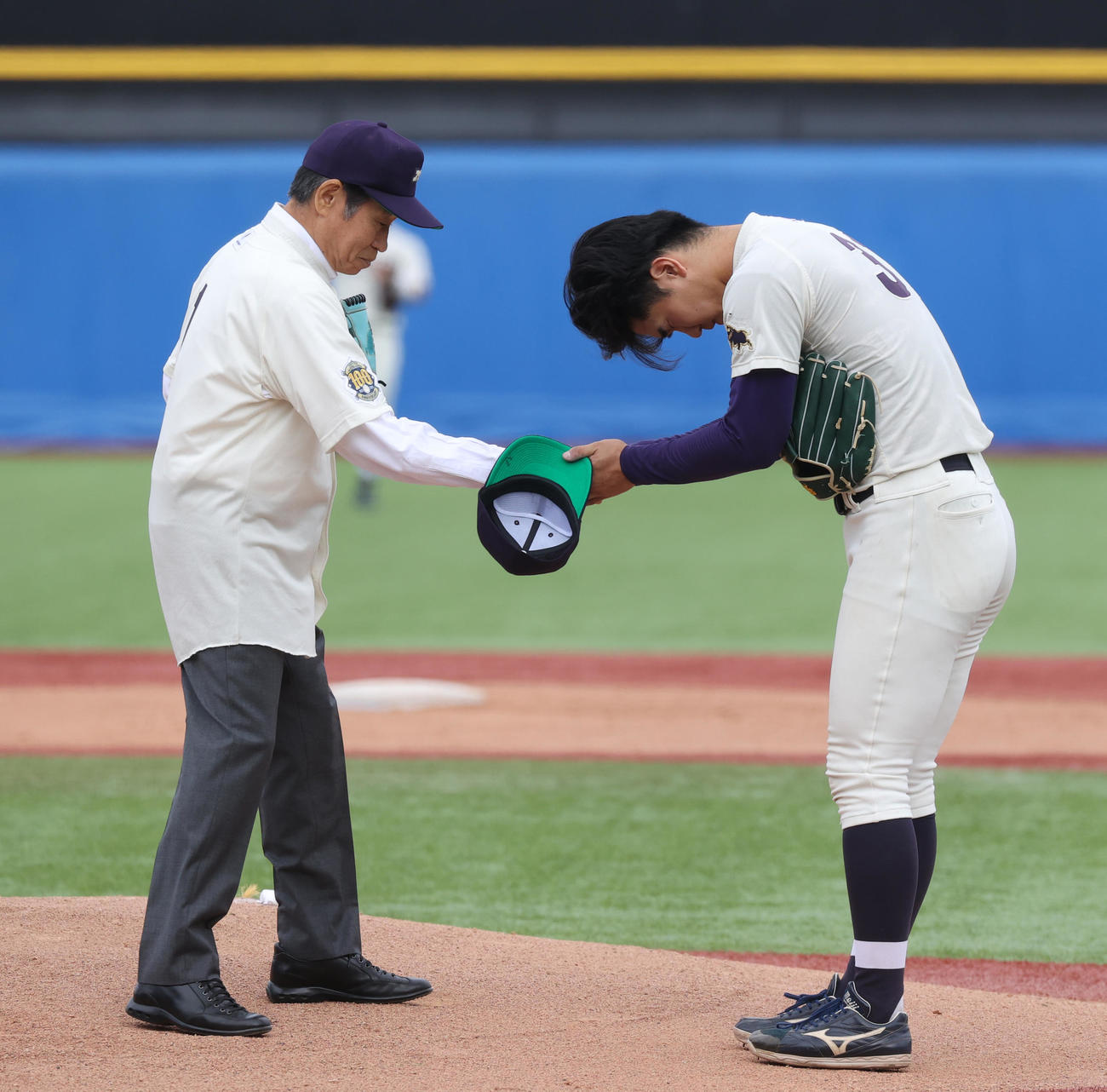 法大対明大　始球式を務めた明大OBの鹿取義隆氏（左）は明大・大室と握手する（撮影・柴田隆二）
