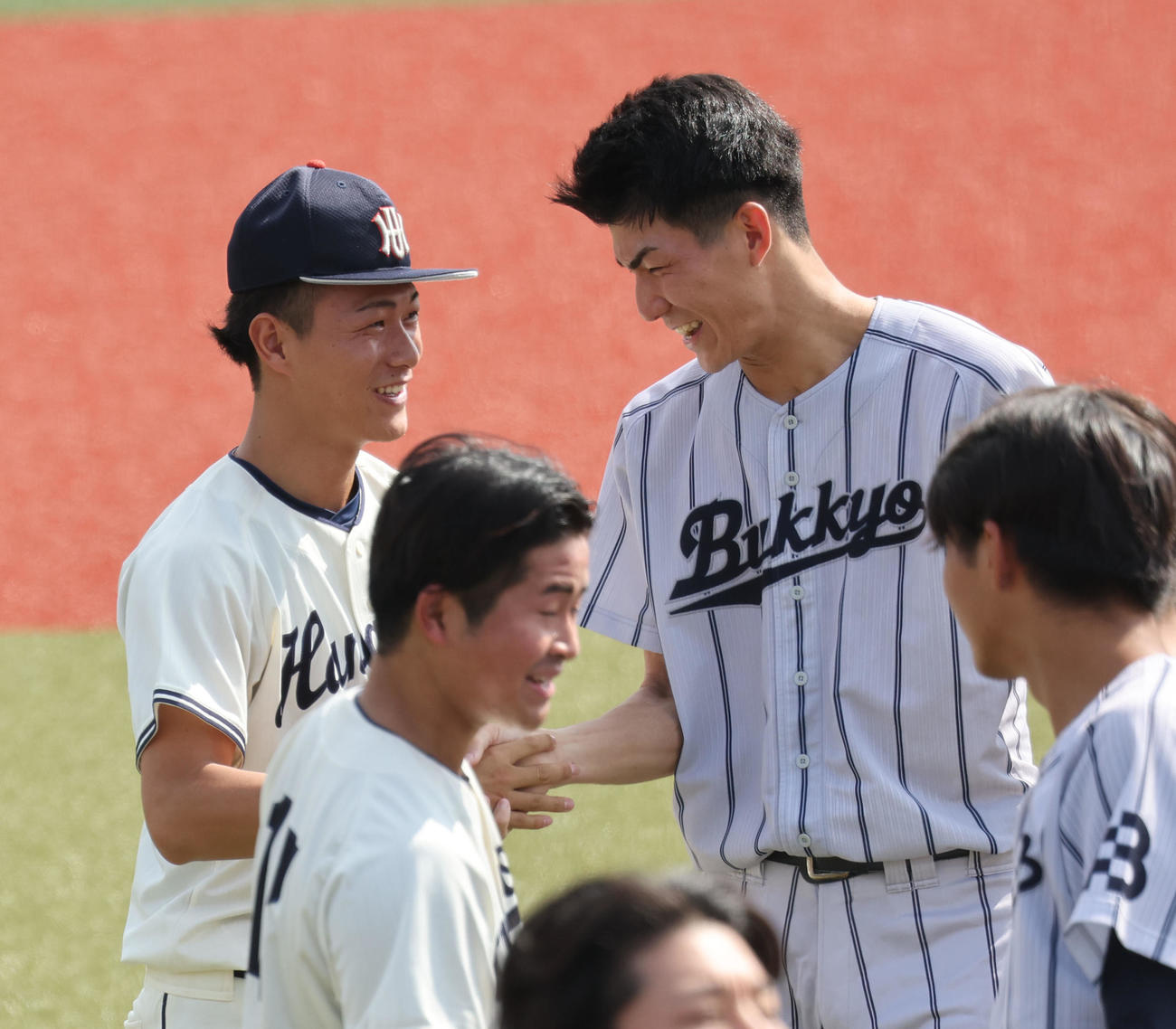 佛教大対花園大　大学で最後の登板を終えた花園大・藤原（左）は投げ合った佛教大・赤木と試合後に笑顔で話す（撮影・西尾就之）
