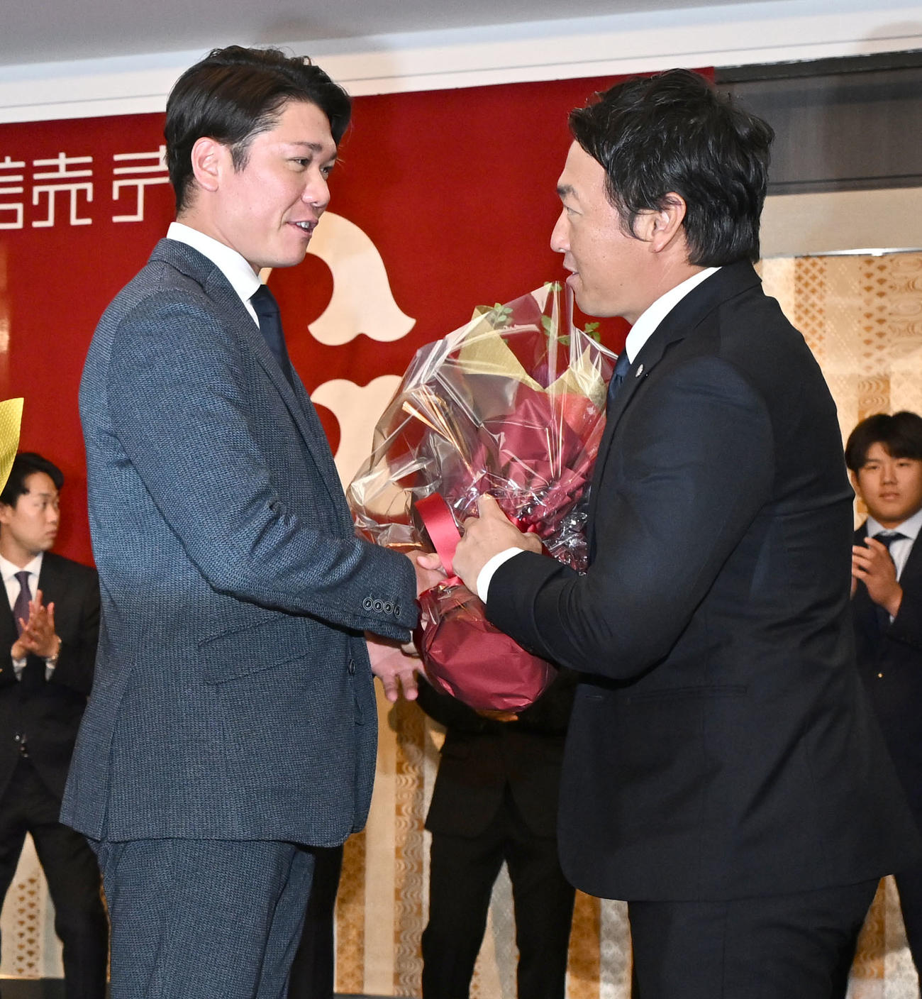 現役引退記者会見に駆けつけた坂本（左）から花束を受け取る巨人長野外野手（撮影・千葉一成）