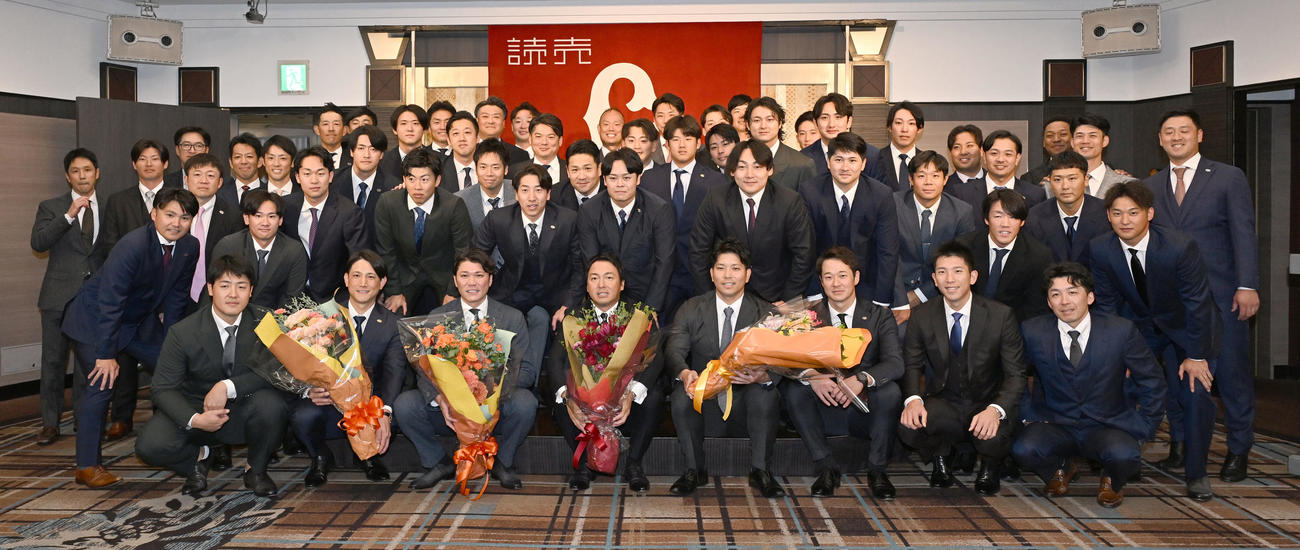 現役引退記者会見に駆けつけた選手やコーチらと記念撮影に臨む巨人長野外野手（前列中央）（撮影・千葉一成）