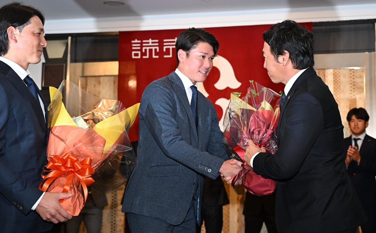 現役引退記者会見に駆けつけた坂本（中央）、小林（左）らから花束を受け取る巨人長野外野手（撮影・千葉一成）
