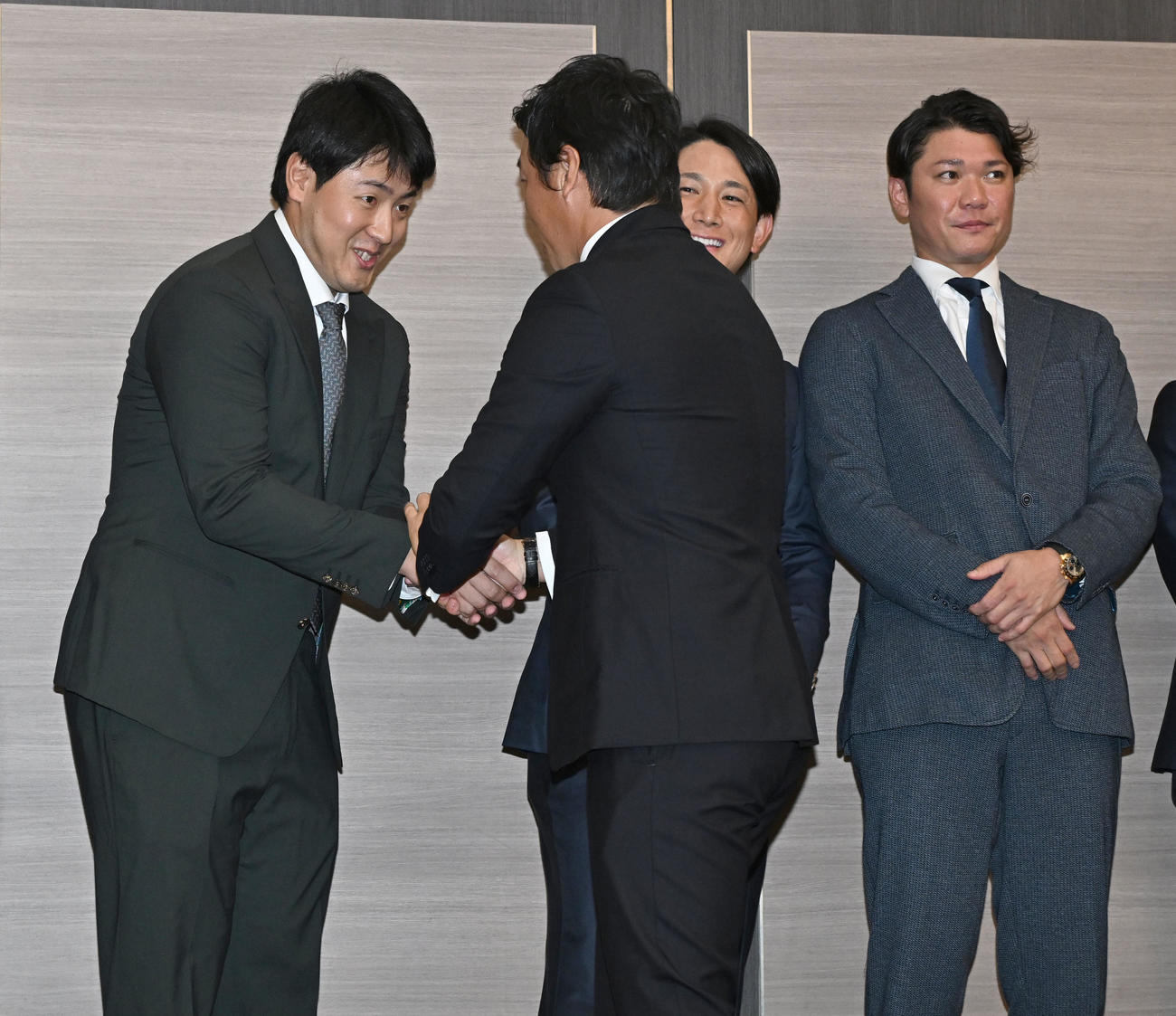 現役引退記者会見に駆けつけ巨人長野と握手で別れを惜しむ岡本（左）ら（撮影・千葉一成）