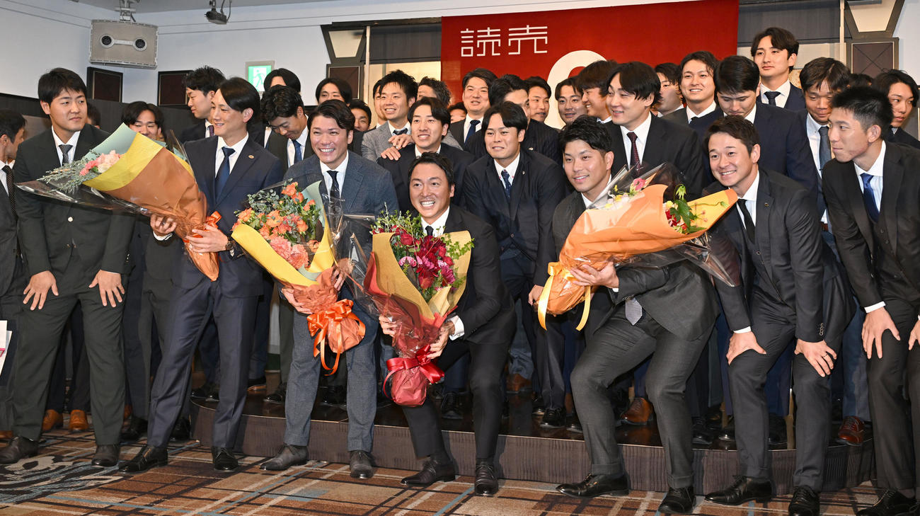 現役引退記者会見に駆けつけた選手やコーチらと記念撮影に臨む巨人長野外野手（前列中央）（撮影・千葉一成）