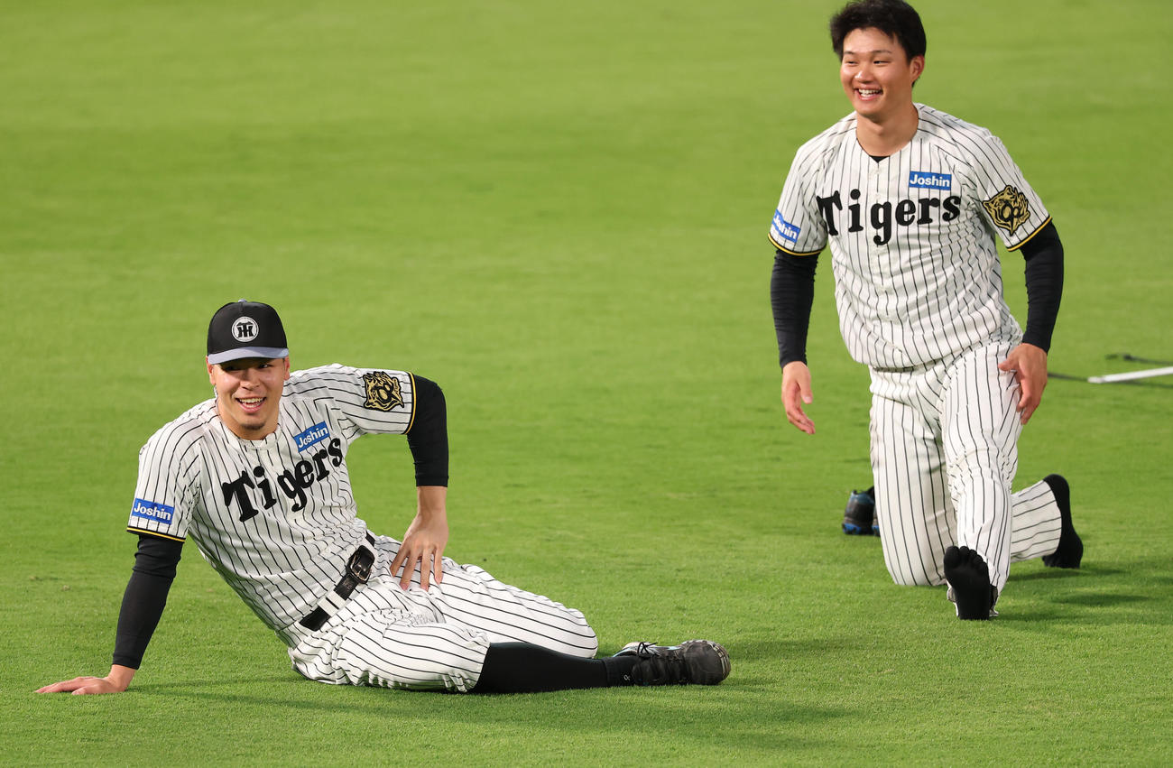 笑顔を見せながらストレッチをする佐藤輝（左）と森下（撮影・上田博志）