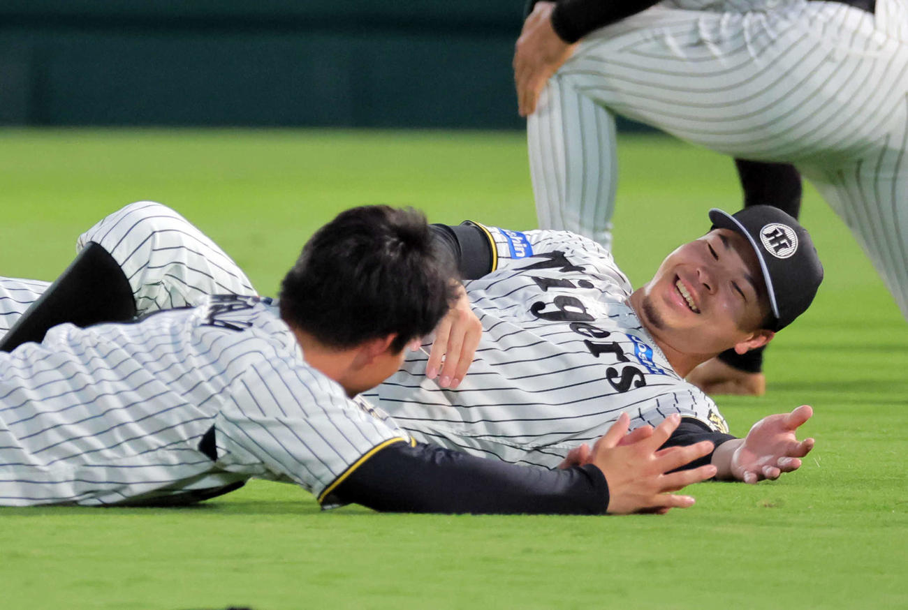 甲子園でストレッチする阪神佐藤輝（右）と森下（撮影・宮崎幸一）