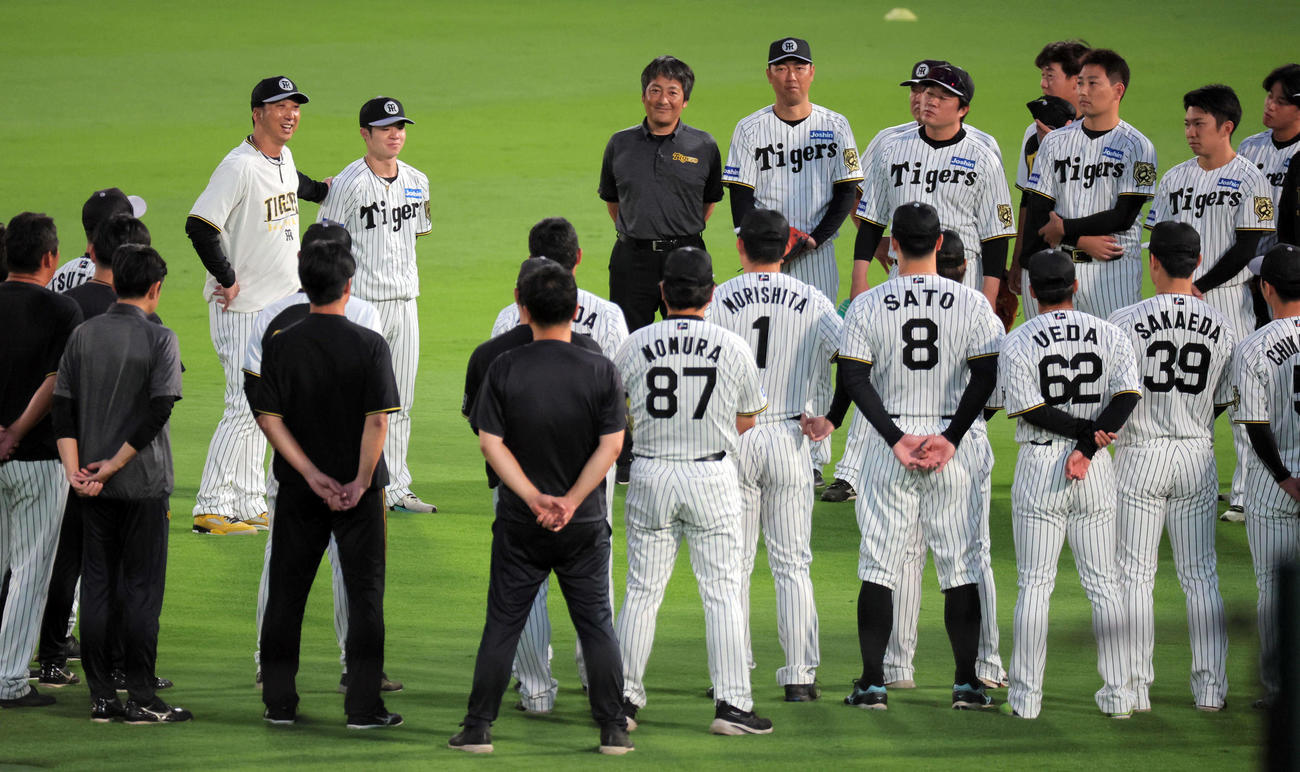 円陣を組む阪神ナインに語りかける藤川監督（左）は、中野の背中に手を回す（撮影・宮崎幸一）