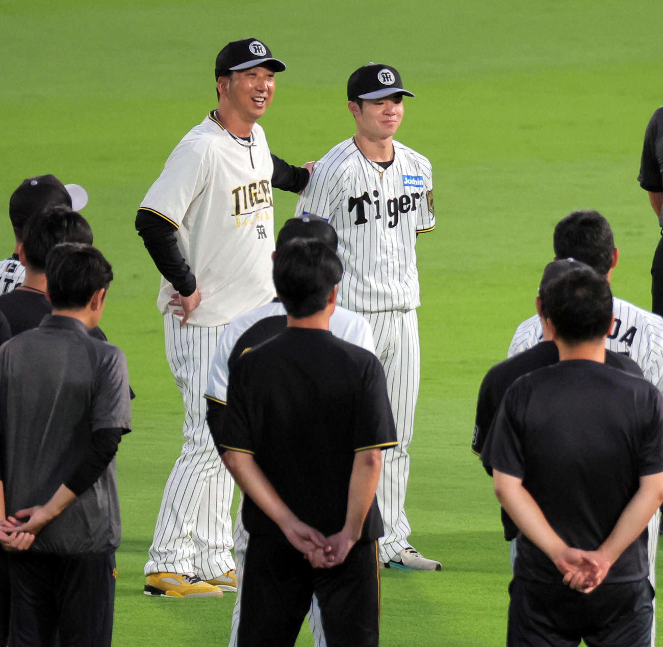 円陣を組む阪神ナインに語りかける藤川監督（左）は、中野の背中に手を回す（撮影・宮崎幸一）