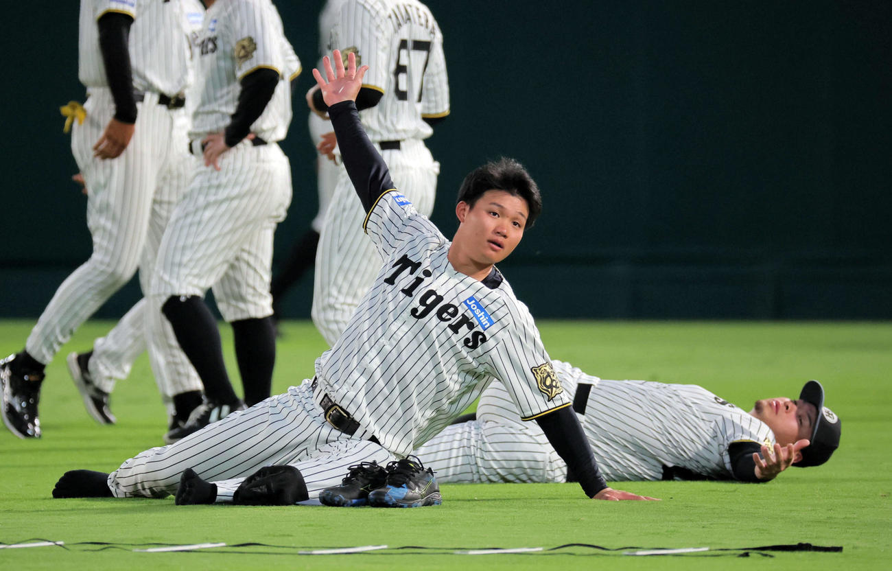甲子園でストレッチする阪神佐藤輝（右）と森下（撮影・宮崎幸一）