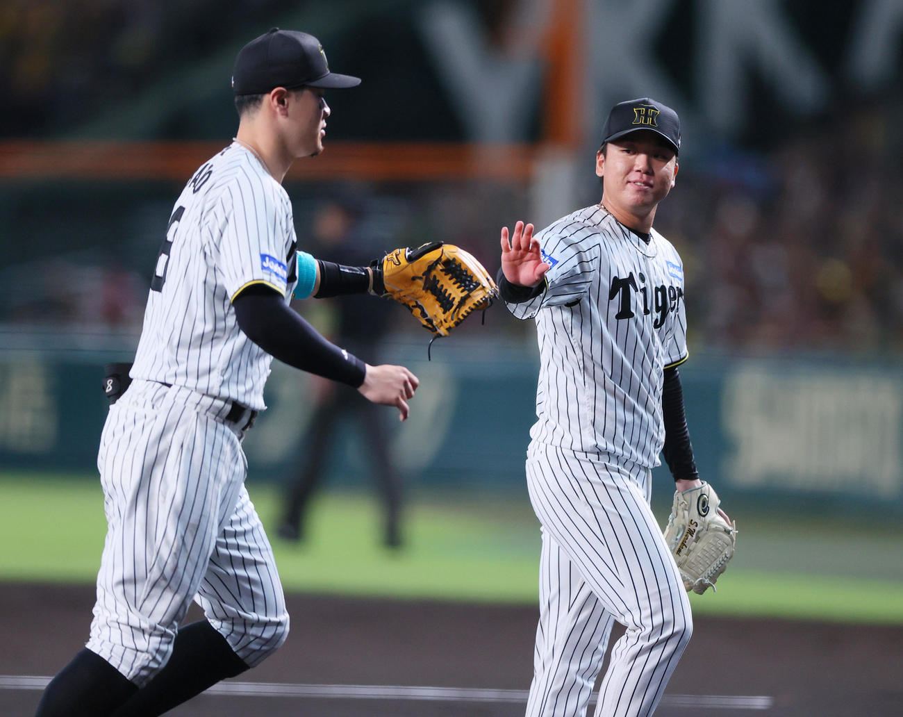 阪神対DeNA 1回表DeNA2死満塁、山本祐大の三ゴロを好捕した佐藤輝（左）を出迎える村上（撮影・上山淳一）