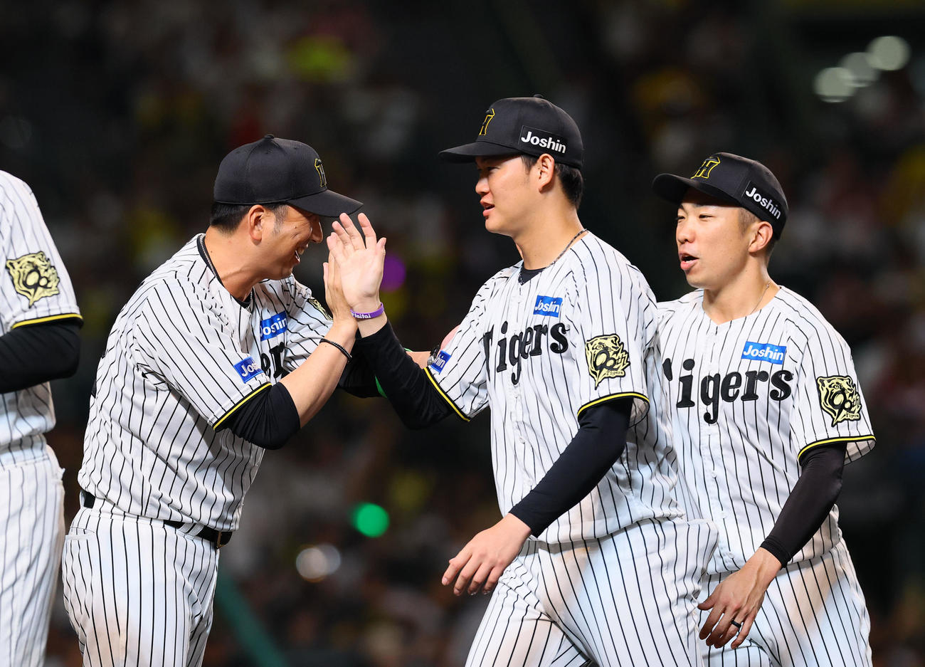 阪神対DeNA DeNAに勝利し、及川（中央）とタッチを交わす阪神藤川監督。右は石井（撮影・藤尾明華）
