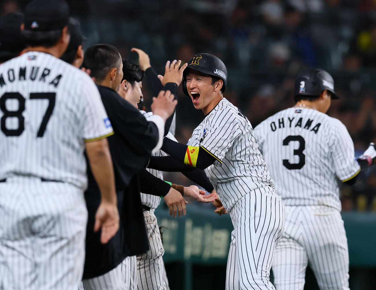 阪神対DeNA 6回裏阪神1死三塁、森下の先制適時打で生還し、ナインとタッチを交わす近本（撮影・藤尾明華）