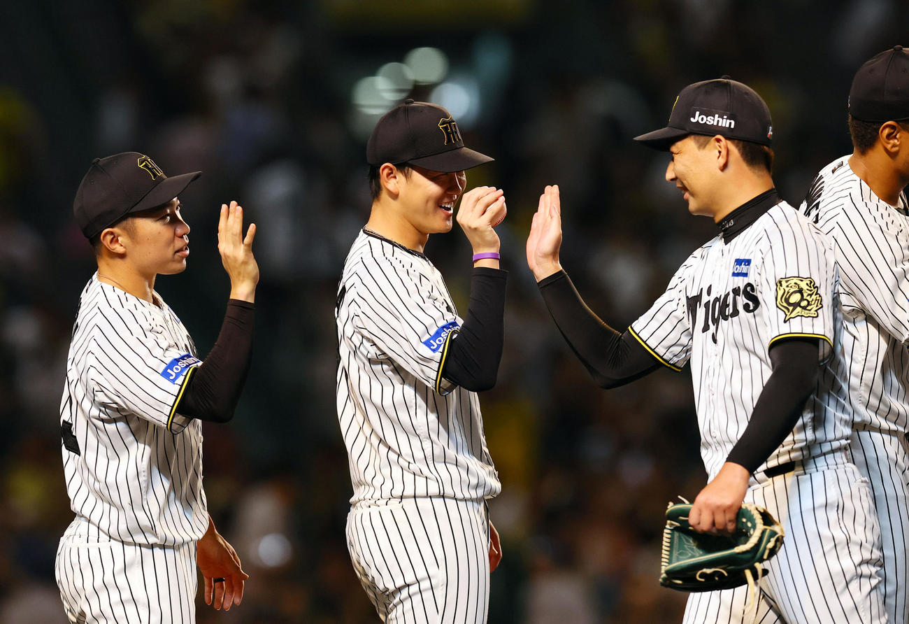 阪神対DeNA DeNAに勝利し、岩崎（右）からウイニングボールを受け取る阪神及川。左は石井（撮影・藤尾明華）