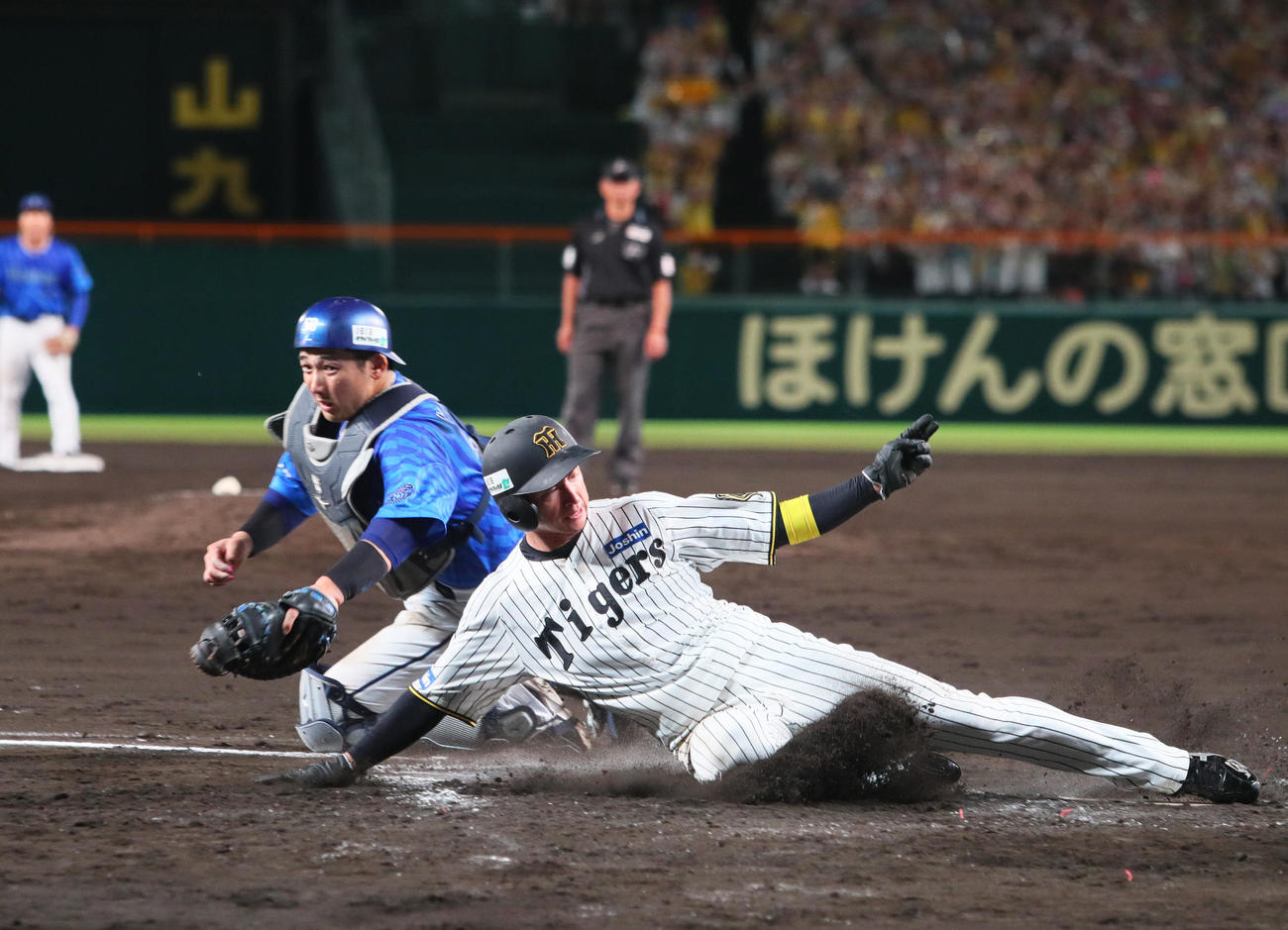 阪神対DeNA 8回裏阪神1死一、二塁、二走近本（手前）は佐藤輝の右前適時打で生還する。捕手山本（撮影・上山淳一