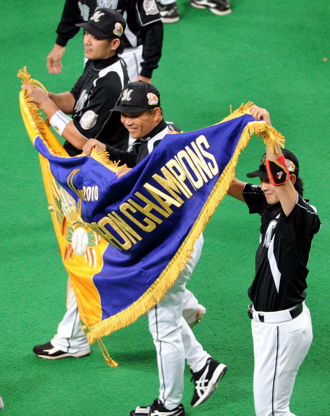 10年11月7日　中日対ロッテ　日本一となり笑顔で優勝フラッグを持つ（手前から）西岡剛、西村徳文監督、サブロー