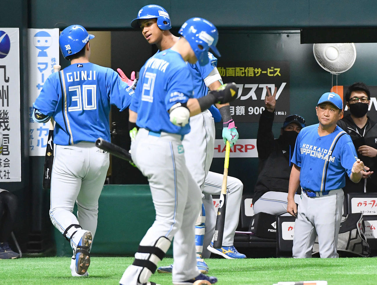 ソフトバンク対日本ハム　1回表日本ハム1死一、三塁、先制の右犠飛を放った郡司（左端）にピースサインを見せる新庄監督（右から3人目）（撮影・岩下翔太）