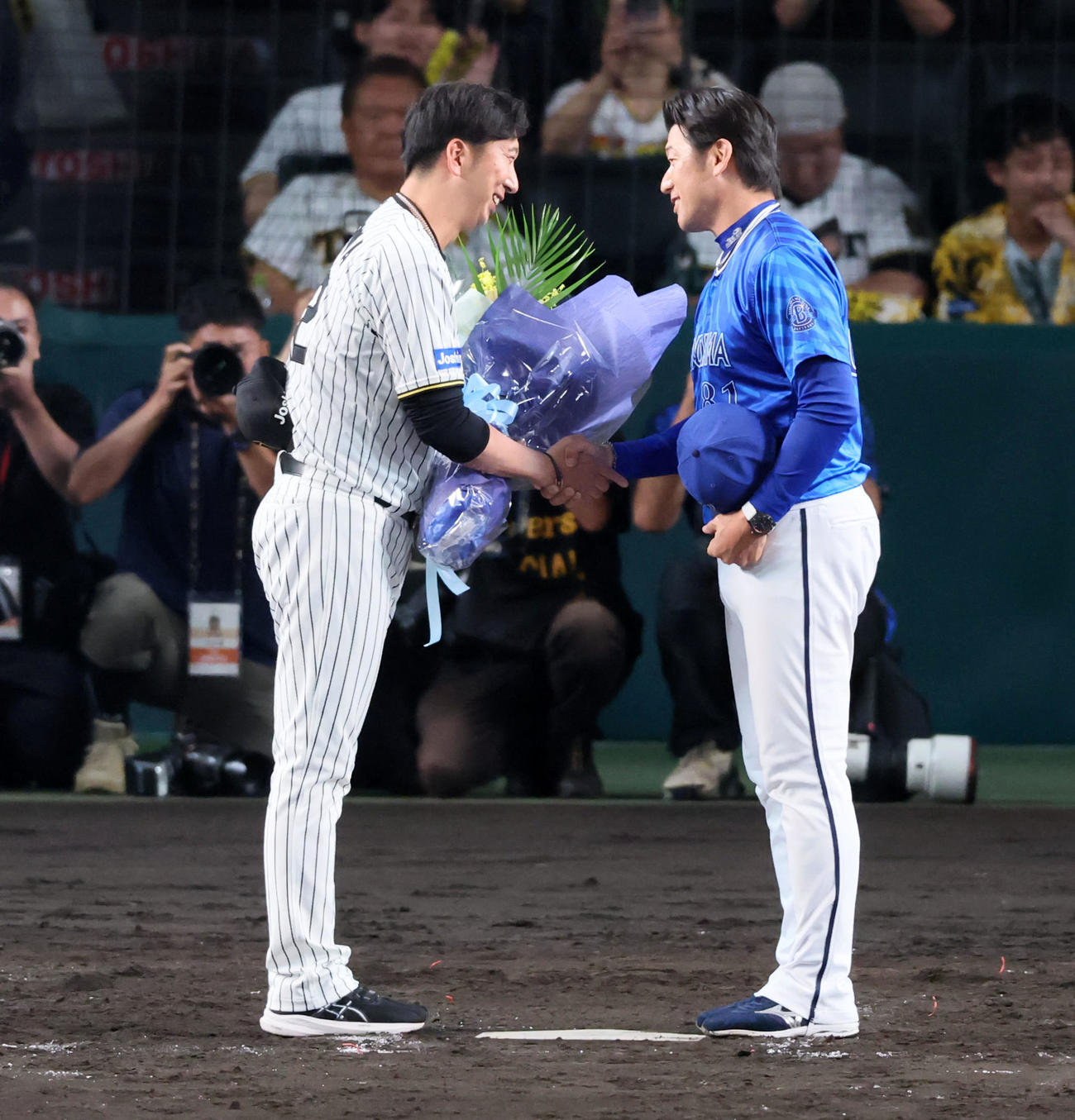 阪神対DeNA　今シーズンで退任するDeNA三浦監督へ阪神藤川監督(左）から花束が贈られた（撮影・加藤哉）