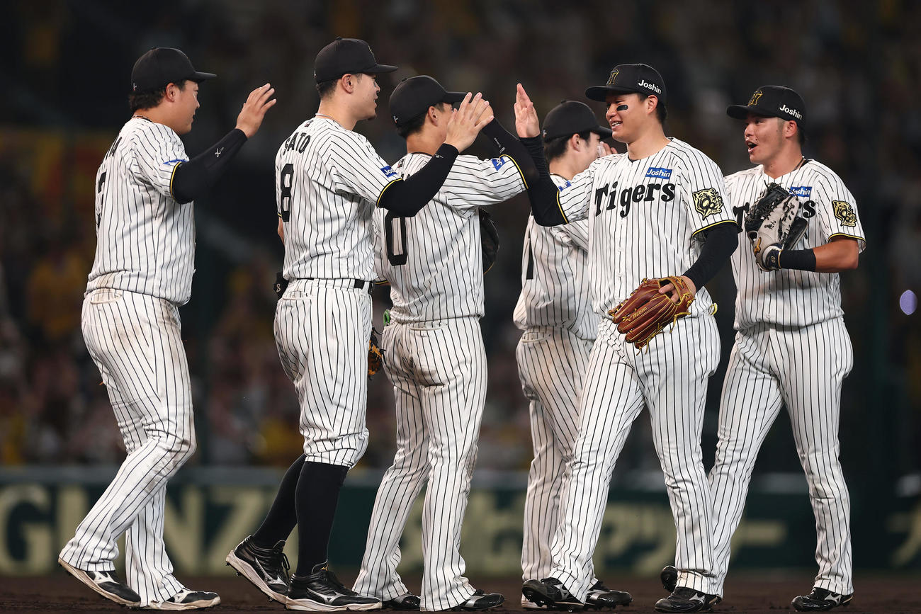 阪神対DeNA DeNAを破って日本シリーズ進出を決め、タッチを交わして喜ぶ阪神の選手たち（撮影・前田充）