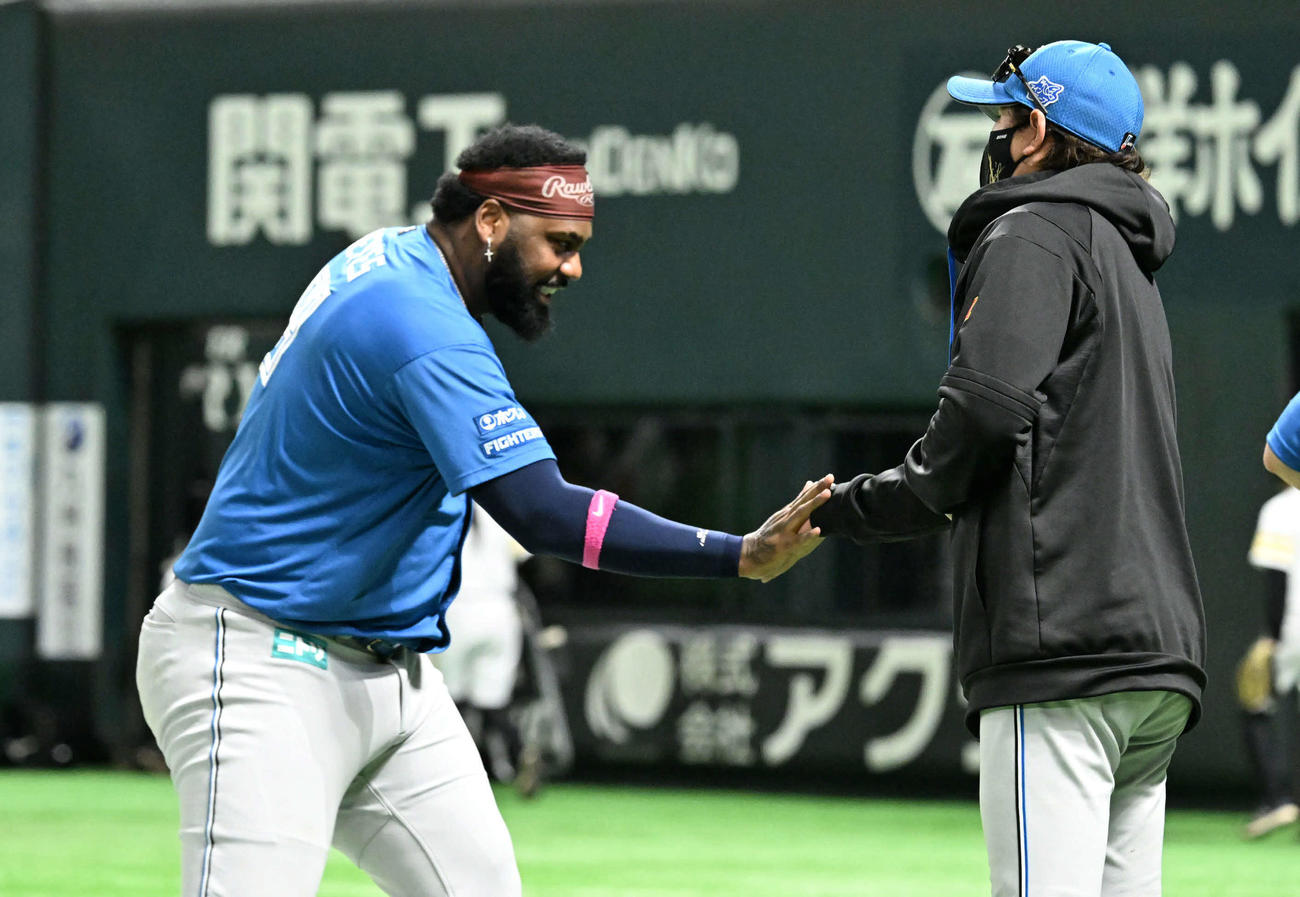 ソフトバンク対日本ハム　勝利を収めタッチを交わす新庄監督（右）とレイエス（撮影・林敢治）
