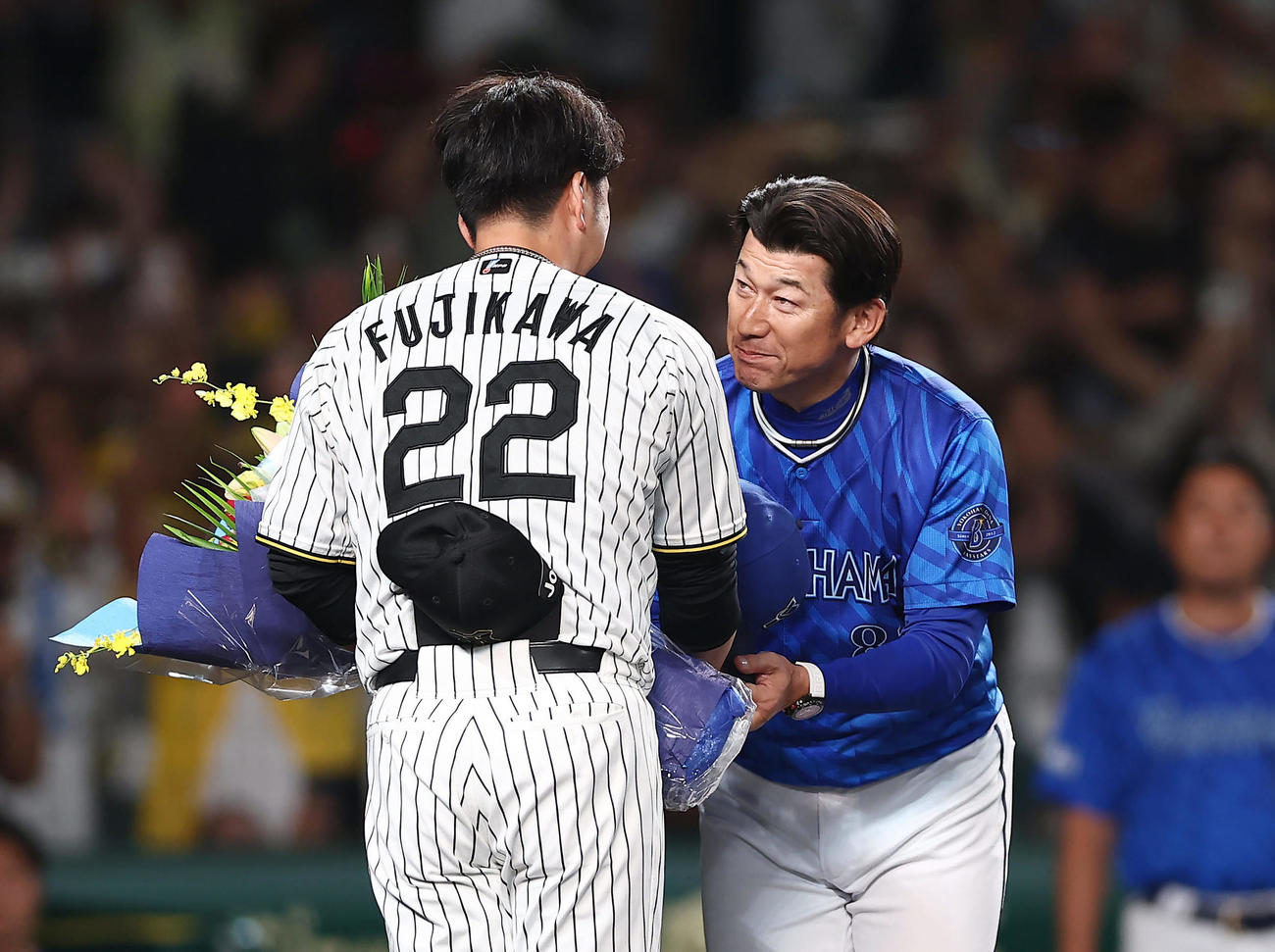 阪神対DeNA　阪神藤川球児監督（左）から花束を受け取り、握手を交わすDeNA三浦大輔監督（撮影・前田充）