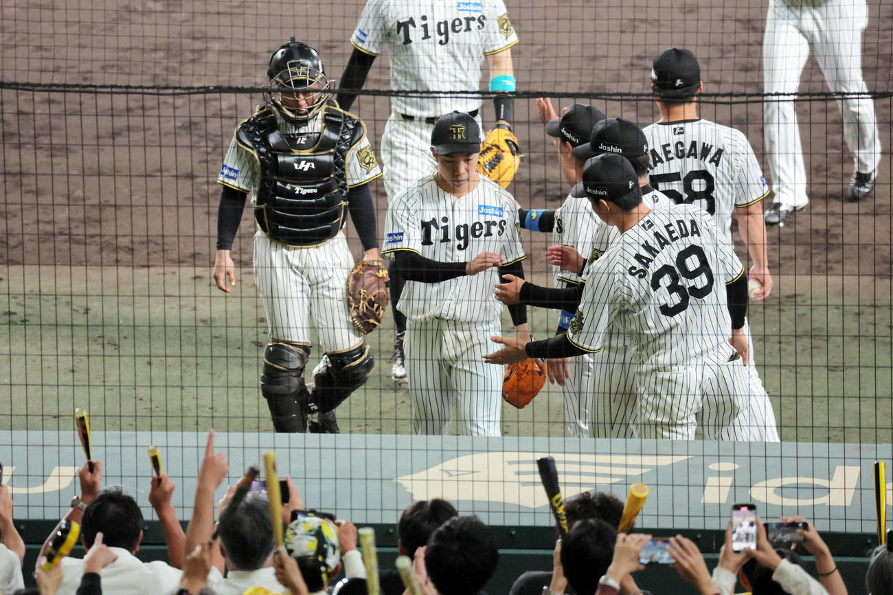 CSファイナル阪神対DeNA 8回表DeNA攻撃終了、ピンチをしのいだ阪神石井（中央）は、ナインに迎えられる（撮影・宮崎幸一）