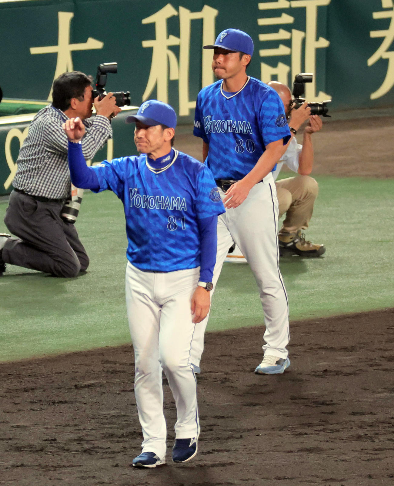 CSファイナル阪神対DeNA　左翼スタンドのファンへのあいさつを終えて引き揚げるDeNA三浦監督（左）と相川コーチ（撮影・宮崎幸一）