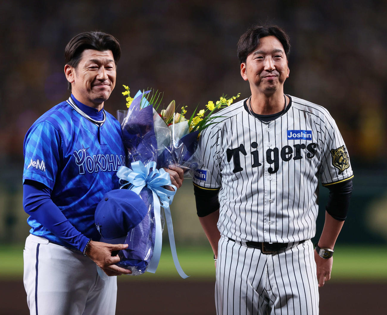 阪神対DeNA　今シーズン限りで退任するDeNA三浦監督（左）は阪神藤川監督から花束を受け取り記念撮影する（撮影・上山淳一）