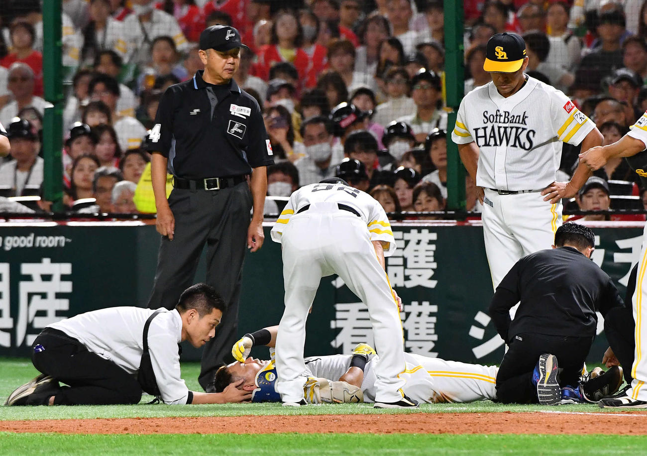 ソフトバンク対日本ハム　3回裏ソフトバンク2死一塁、一ゴロで嶋田一塁塁審（左奥）と交錯して後頭部を強打し、その場に倒れる中村（撮影・岩下翔太）