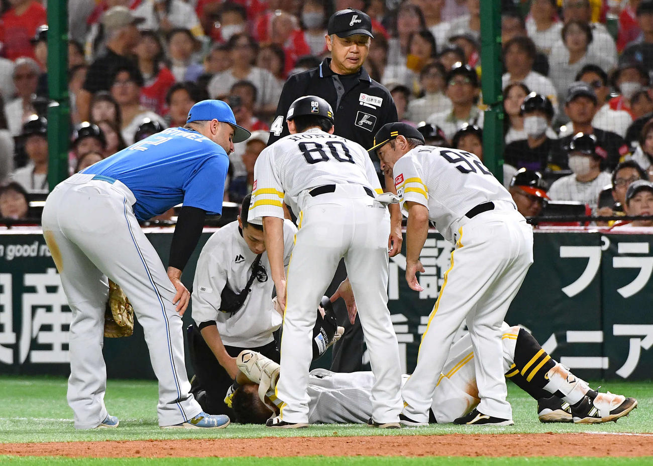 ソフトバンク対日本ハム　3回裏ソフトバンク2死一塁、一ゴロで嶋田一塁塁審（奥）と交錯して後頭部を強打し、その場に倒れる中村（撮影・岩下翔太）